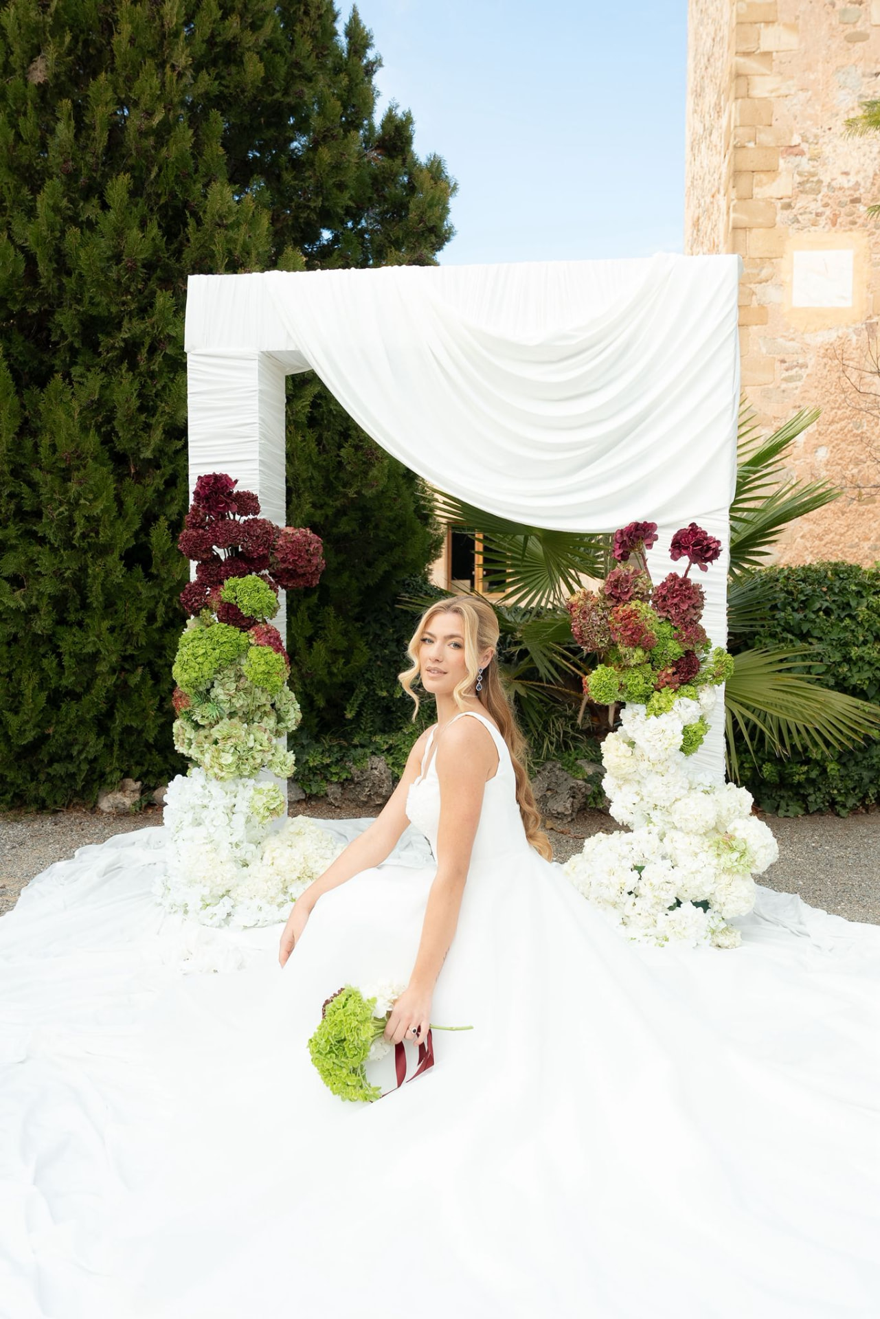 Novia junto a un arco floral en una finca de Cataluña