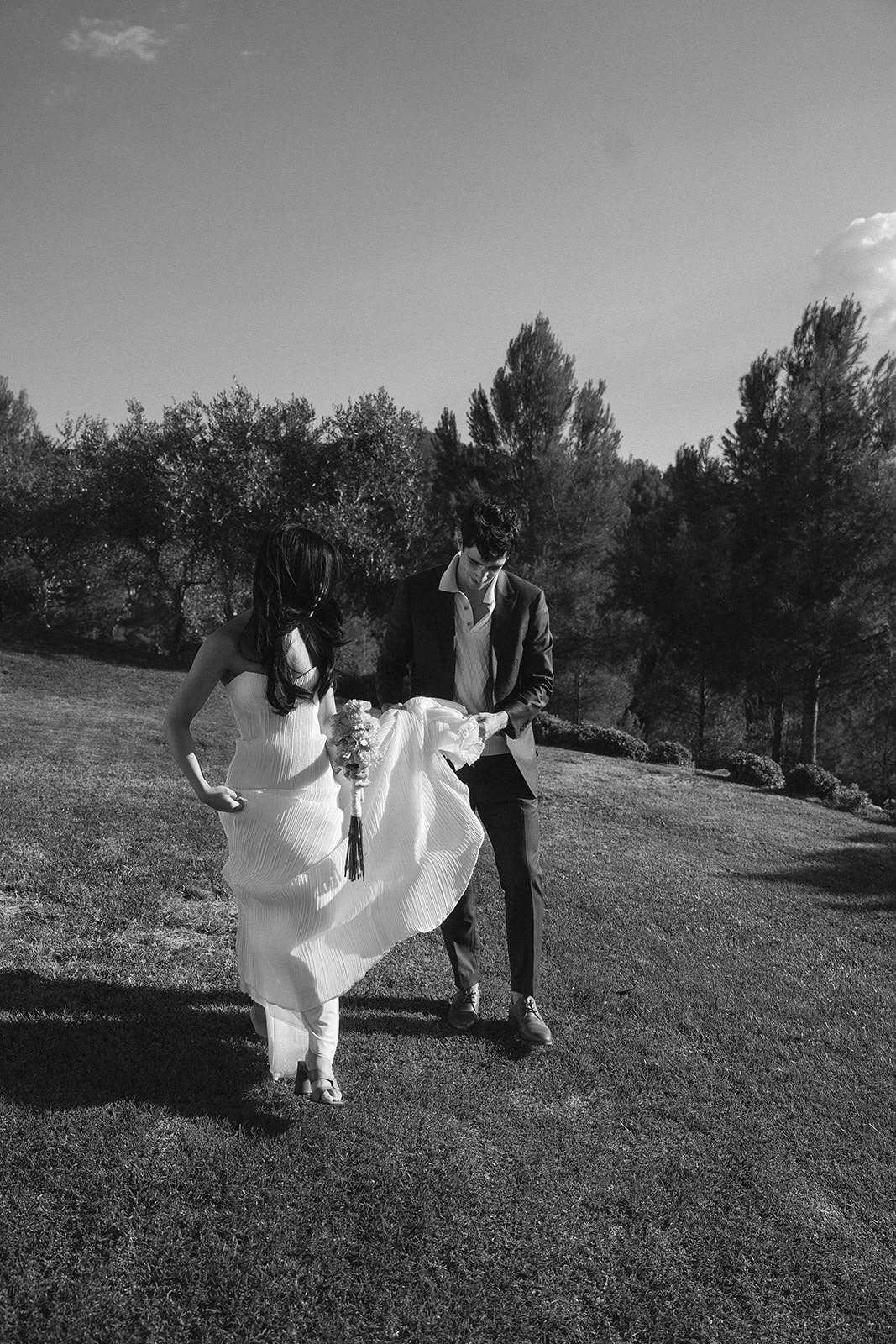 Pareja de novios caminando por el jardín en blanco y negro